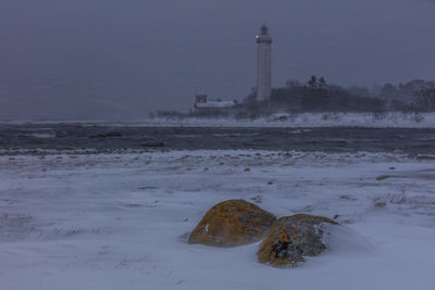 Scenic view of lighthouse against sky during winter