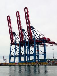 Cranes at construction site against sky