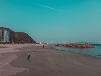 Scenic view of beach against clear blue sky