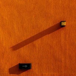 Shadow of man standing on yellow wall