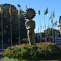 Statue amidst plants against sky