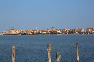 Sea by city against clear blue sky