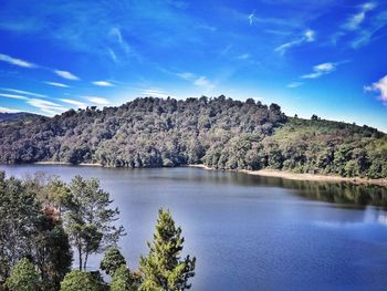 Scenic view of lake and mountains against blue sky