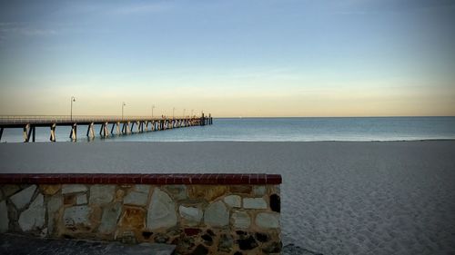 Pier over sea against sky during sunset