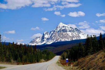 Road by mountains against sky