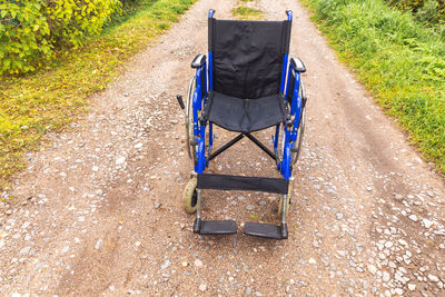 High angle view of chair on footpath in park