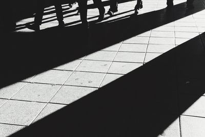 Low section of silhouette man standing on tiled floor