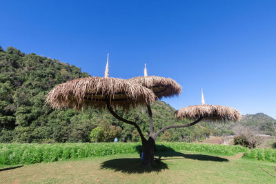 Traditional windmill on landscape against clear blue sky