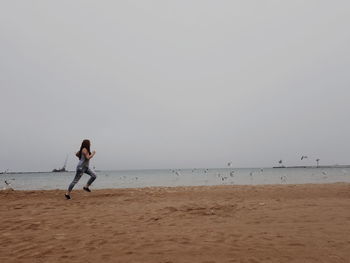 Full length of man on beach against clear sky