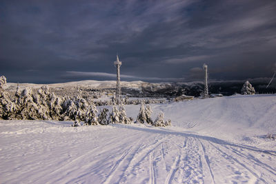 Scenic view of snow covered field against sky