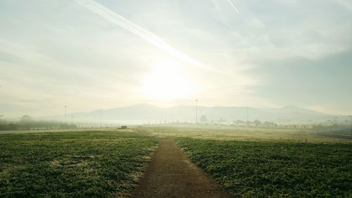 Scenic view of field against cloudy sky