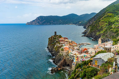 High angle view of city by sea against sky