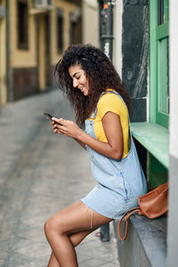 Side view of young woman using mobile phone