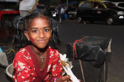 Portrait of young woman standing on street