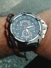 High angle view of hand holding clock