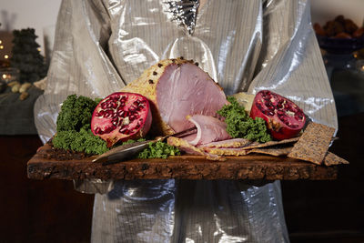 Woman holding ham on wooden board