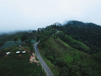 Scenic view of road by mountains against sky