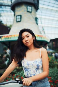 Beautiful young woman standing against building