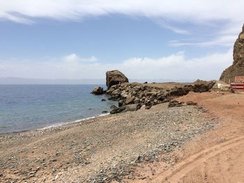 Rocks on beach against sky