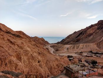 Scenic view of mountains by sea against sky