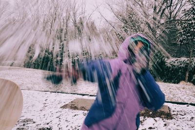 Young woman on snow covered tree