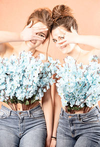 Portrait of beautiful woman against white flowering plants