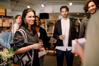 Saleswoman talking to customers while showing perfume at store