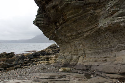 Rock formations by sea against sky