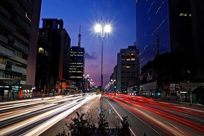 Light trails on road along buildings at night