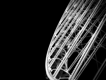 Low angle view of illuminated ferris wheel against black background