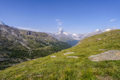 Scenic view of mountains against blue sky