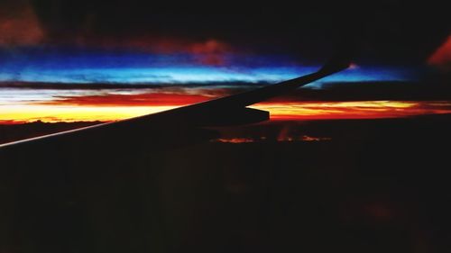 Close-up of silhouette airplane against sky during sunset