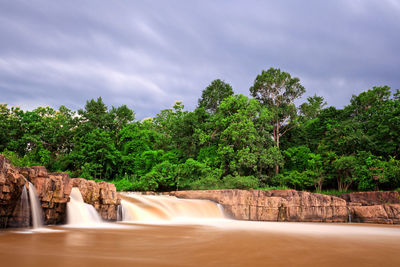 Scenic view of waterfall against sky