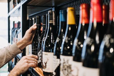 Cropped hand of man holding wine bottles