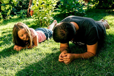 Siblings lying on field