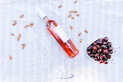 High angle view of bottle with berries on table