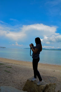 Full length of man standing on beach against sky