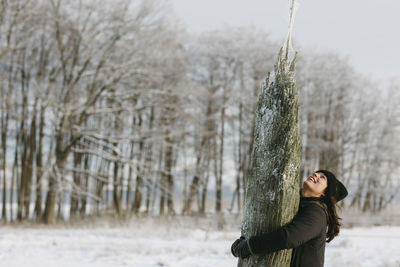 Woman carrying christmas tree at winter