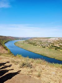 Scenic view of landscape against blue sky