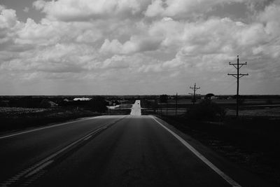 Empty road against cloudy sky