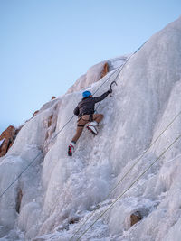 Low angle view of man surfing on rock against sky