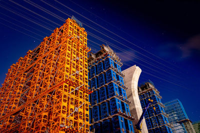 Low angle view of skyscrapers against sky at night