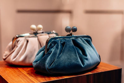 Velvet blue and white clutches on a wooden stand. fashion details, women's accessories