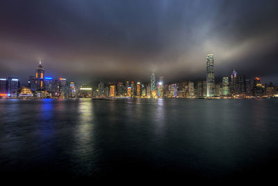 Illuminated buildings in city against sky at night