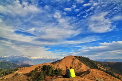 Rear view of woman looking at mountain against sky