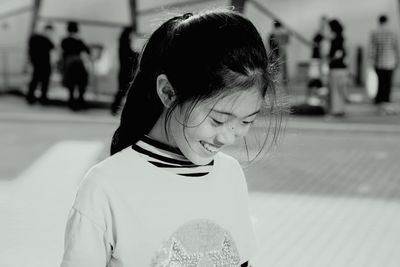 Smiling girl standing on footpath