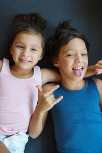 Brother and sister laying down making funny faces