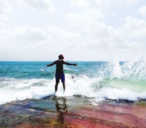 Full length of man standing on sea shore against sky