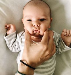 Cropped image of mother playing with cute baby girl