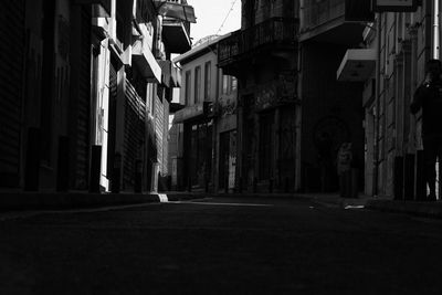 Empty road amidst buildings in city at night